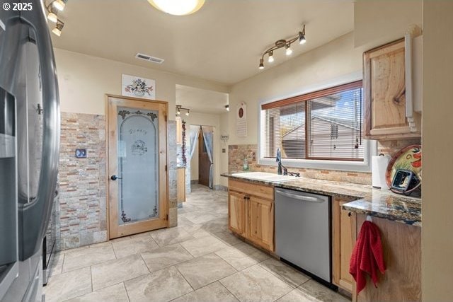 kitchen with sink, decorative backsplash, stainless steel appliances, and stone countertops