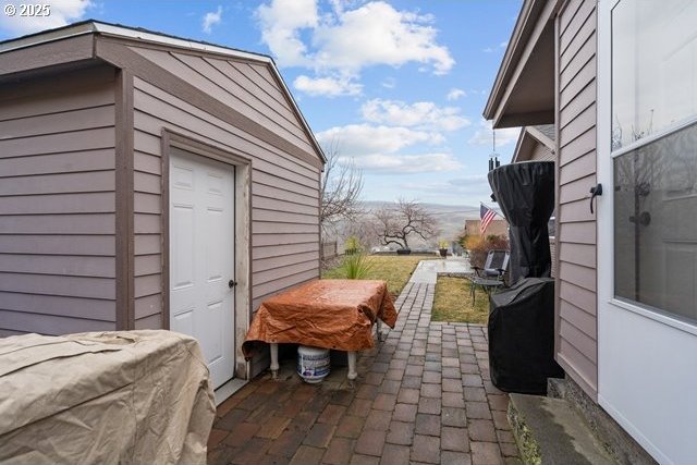 view of patio featuring area for grilling and a shed