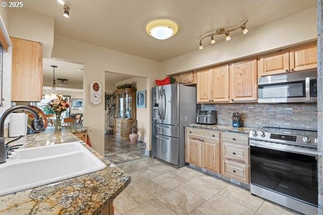 kitchen featuring stainless steel appliances, sink, light brown cabinetry, and light stone counters