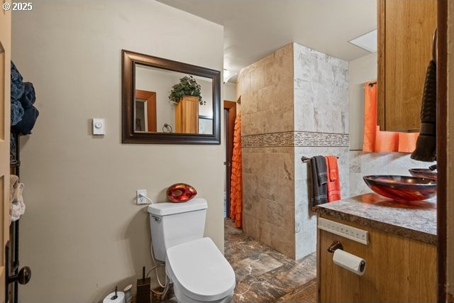 bathroom with vanity, toilet, and tile walls