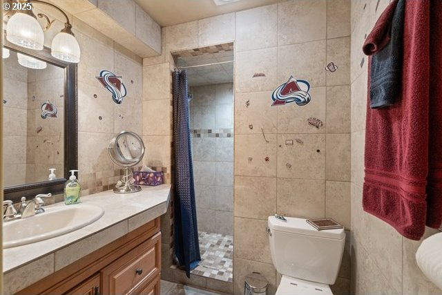 bathroom featuring tile walls, vanity, curtained shower, and toilet