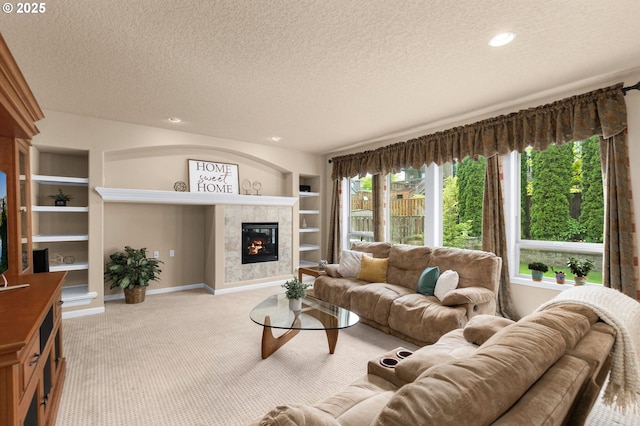 1116 Parkside Ave, Forest Grove, OR 97116 - living room with carpet flooring, a textured ceiling, built in features, a tiled fireplace, and baseboards