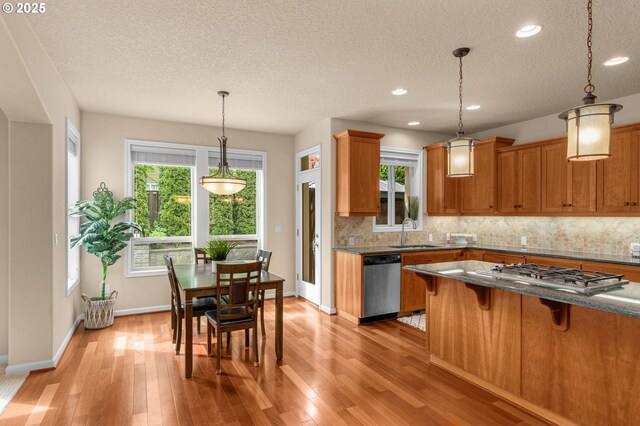 1116 Parkside Ave, Forest Grove, OR 97116 - kitchen featuring appliances with stainless steel finishes, a sink, a textured ceiling, tasteful backsplash, and a breakfast bar