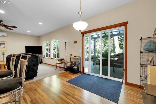 interior space with an AC wall unit, baseboards, ceiling fan, and light wood-type flooring