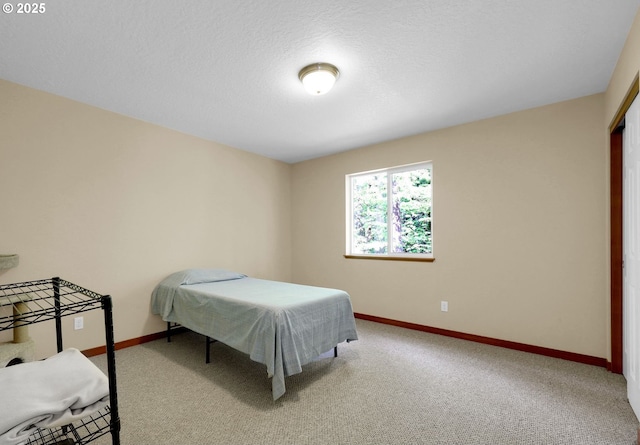 bedroom featuring baseboards and carpet