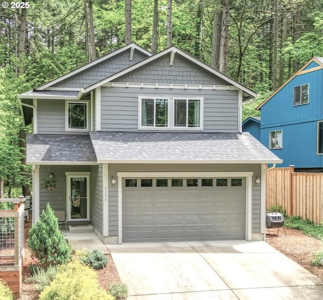 view of front of property with fence, a shingled roof, driveway, and a garage