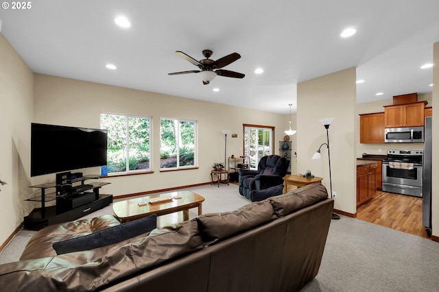 living area with recessed lighting, baseboards, light colored carpet, and ceiling fan