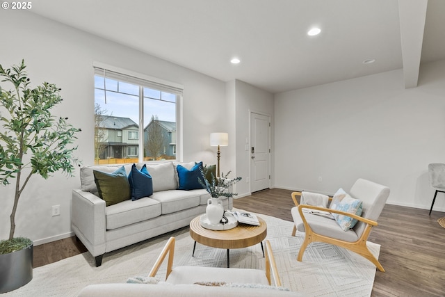 living area featuring baseboards, wood finished floors, and recessed lighting