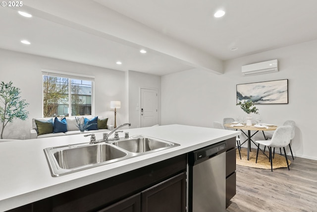 kitchen with open floor plan, light wood-type flooring, stainless steel dishwasher, a sink, and a wall mounted AC