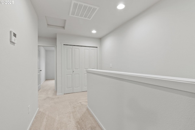 corridor featuring recessed lighting, light carpet, visible vents, baseboards, and attic access