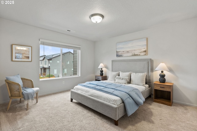 carpeted bedroom featuring a textured ceiling, visible vents, and baseboards