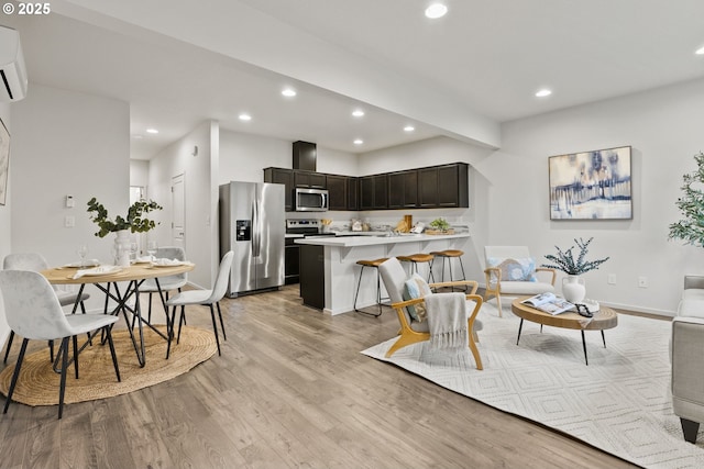 kitchen featuring recessed lighting, stainless steel appliances, a peninsula, light countertops, and light wood-type flooring