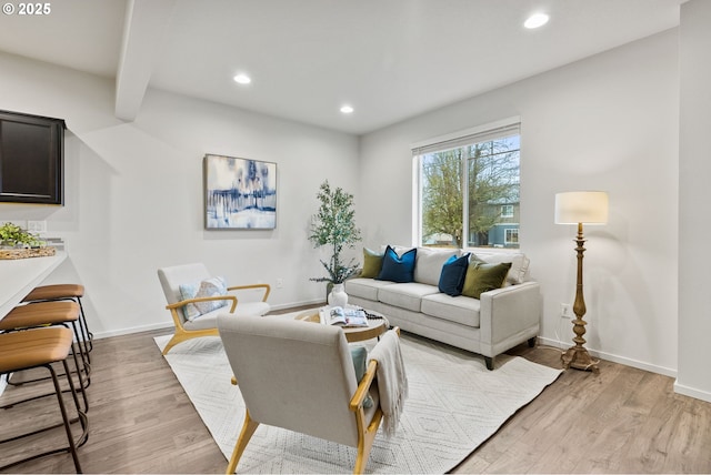 living room with baseboards, light wood finished floors, and recessed lighting