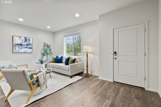 living room with baseboards, wood finished floors, and recessed lighting