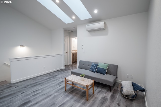 living room with vaulted ceiling with skylight, a wall mounted AC, and hardwood / wood-style floors