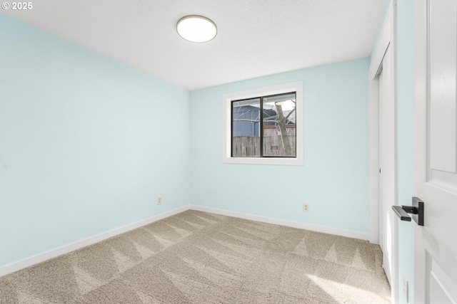 unfurnished bedroom featuring baseboards, carpet floors, and a closet