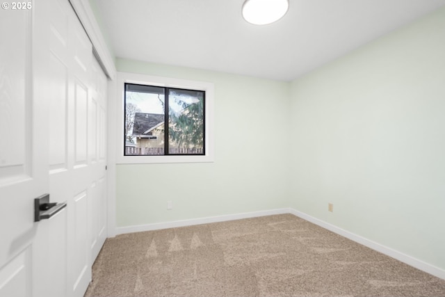 empty room featuring baseboards and carpet floors