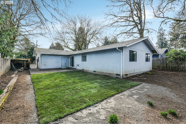 rear view of house featuring crawl space, a lawn, a patio, and a fenced backyard