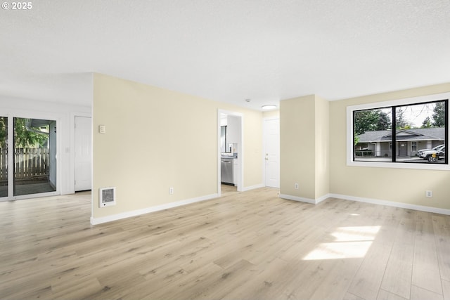 spare room with baseboards, a healthy amount of sunlight, and light wood-style flooring