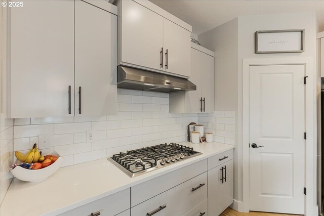 12505 NE 102nd Way, Vancouver, WA 98682 - kitchen with under cabinet range hood, stainless steel gas cooktop, light countertops, and tasteful backsplash