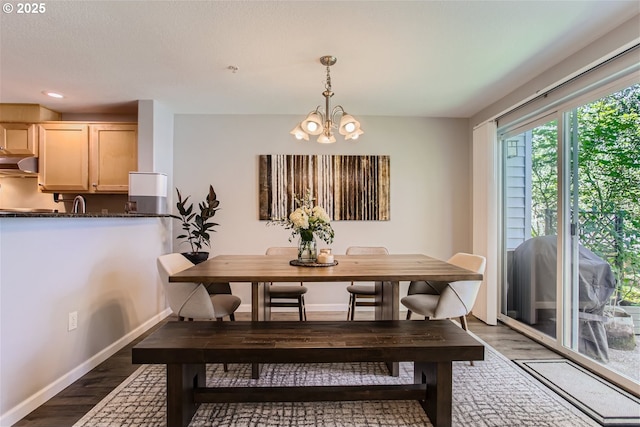 dining room featuring dark wood-style floors, a chandelier, and baseboards