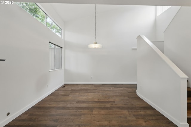 1571 NW Tanasbrook Ct, Beaverton, OR 97006 - unfurnished dining area with a towering ceiling, dark wood-type flooring, baseboards, and stairs