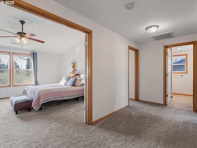 bedroom featuring light colored carpet and a textured ceiling