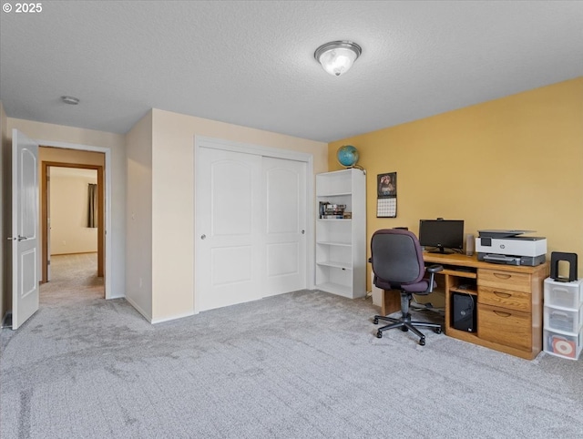 office with light colored carpet and a textured ceiling