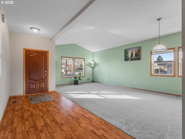 foyer featuring hardwood / wood-style flooring and vaulted ceiling