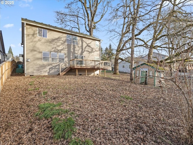 rear view of property with a wooden deck and a storage unit