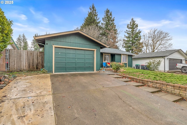 ranch-style house featuring an attached garage, driveway, and fence