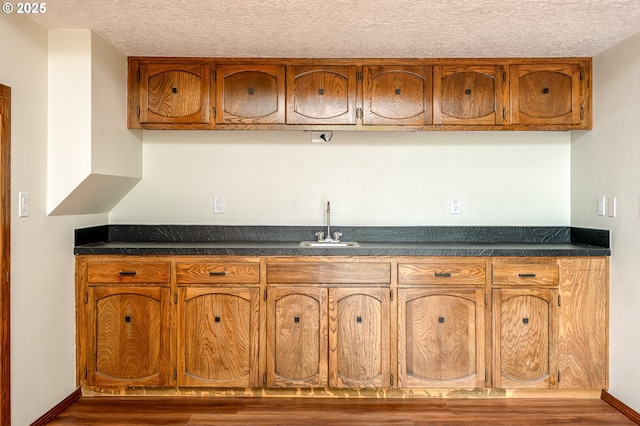 2011 SW 29th Dr, Gresham, OR 97080 - kitchen with brown cabinets, dark countertops, wood finished floors, and a textured ceiling
