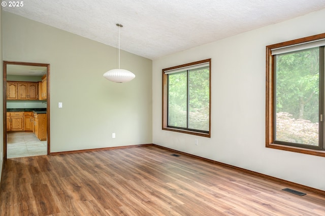 2011 SW 29th Dr, Gresham, OR 97080 - unfurnished room with vaulted ceiling, wood finished floors, plenty of natural light, and a textured ceiling