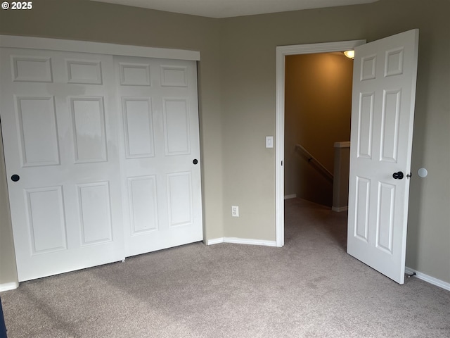 unfurnished bedroom featuring light carpet and a closet