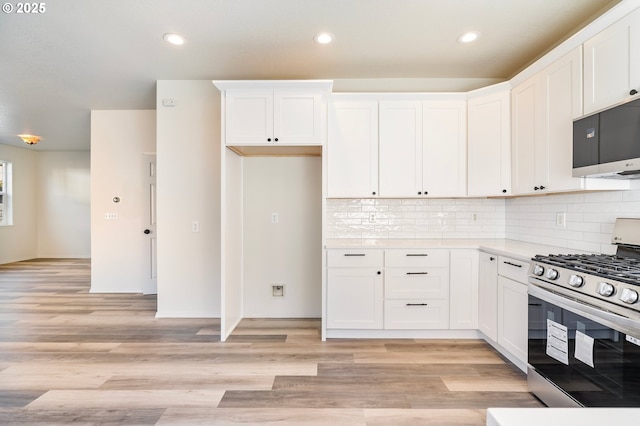 kitchen featuring light hardwood / wood-style flooring, stainless steel gas range, and white cabinets