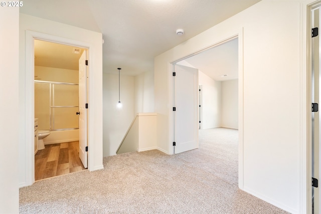 hallway featuring light colored carpet