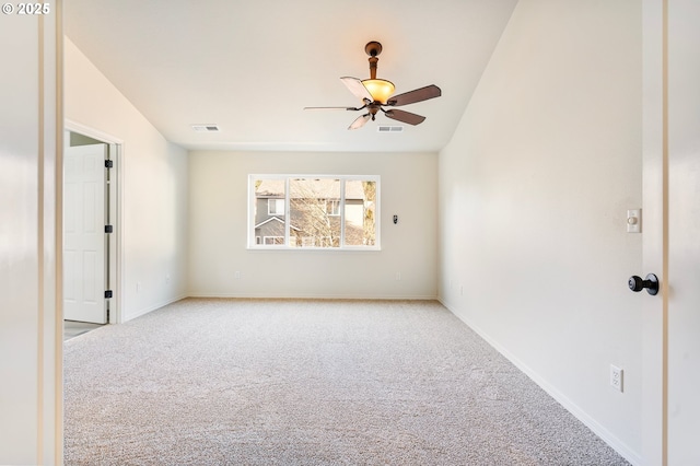 empty room featuring vaulted ceiling, light colored carpet, and ceiling fan