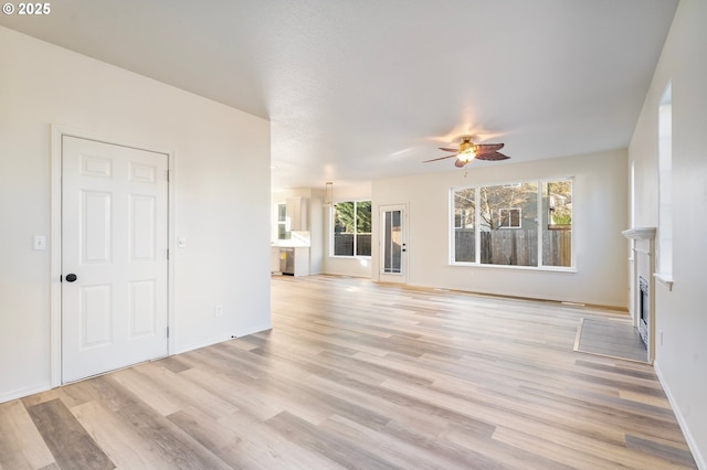 unfurnished living room featuring ceiling fan and light wood-type flooring