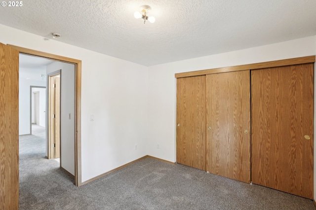 unfurnished bedroom with a textured ceiling, baseboards, carpet, and a closet
