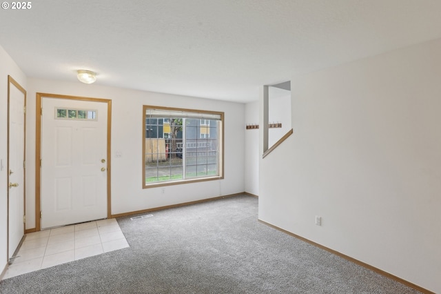 entryway with baseboards, carpet, and visible vents