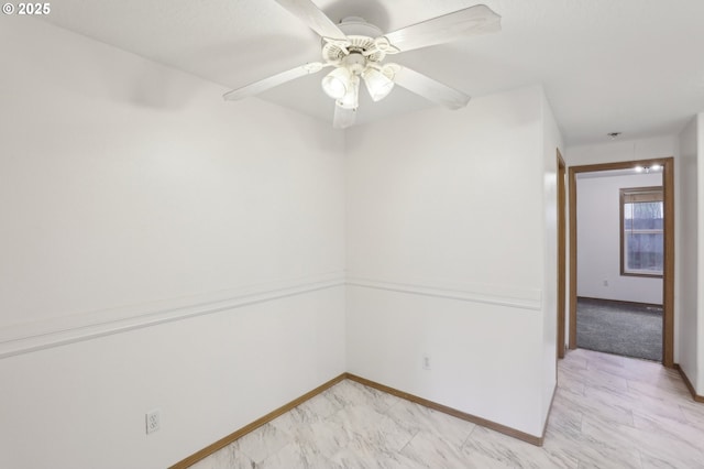 spare room featuring baseboards, a ceiling fan, and marble finish floor