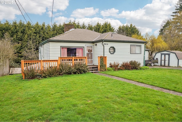 view of front of property with a front yard, a chimney, a storage shed, a deck, and an outdoor structure