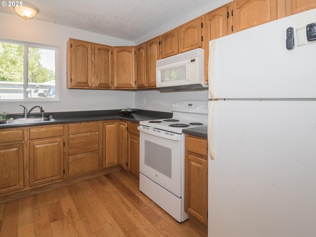 2712 SE 138th Ave Unit 53, Portland, OR 97236 - kitchen featuring white appliances, dark countertops, brown cabinets, and a textured ceiling