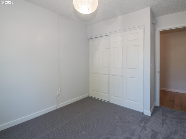 2712 SE 138th Ave Unit 53, Portland, OR 97236 - unfurnished bedroom featuring a closet, dark carpet, and a textured ceiling