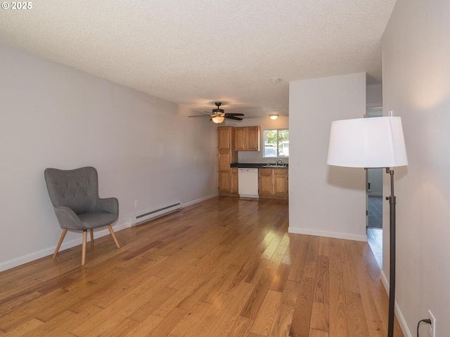 2712 SE 138th Ave Unit 53, Portland, OR 97236 - unfurnished living room with a baseboard heating unit, light wood-style floors, a textured ceiling, and ceiling fan
