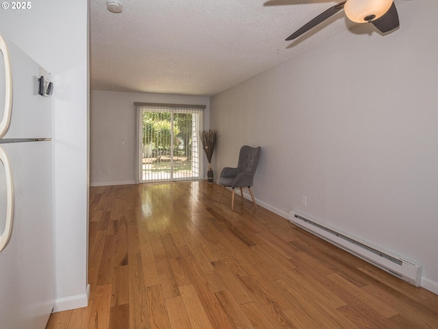 2712 SE 138th Ave Unit 53, Portland, OR 97236 - unfurnished room featuring a baseboard radiator, a ceiling fan, a textured ceiling, and light wood-style flooring