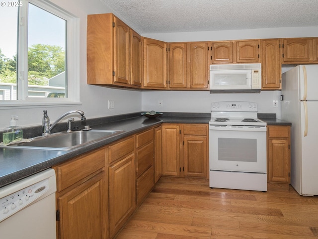 2712 SE 138th Ave Unit 53, Portland, OR 97236 - kitchen featuring white appliances, brown cabinetry, dark countertops, and a textured ceiling