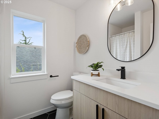 1534 N Schofield St, Portland, OR 97217 - bathroom with toilet, vanity, tile patterned flooring, and baseboards