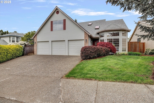 view of front facade with a front lawn, fence, brick siding, an attached garage, and driveway