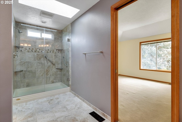 bathroom with baseboards, plenty of natural light, and a shower stall